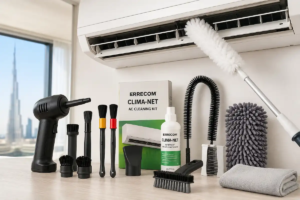 UAE apartment split AC unit being cleaned with microfiber duster and professional AC vent cleaning tools including detailing brushes, vacuum attachments, compressed air duster, and AC cleaning kit displayed on table near Dubai skyline window view.