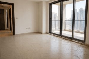 empty Dubai apartment before move-in cleaning with visible dust near balcony doors.